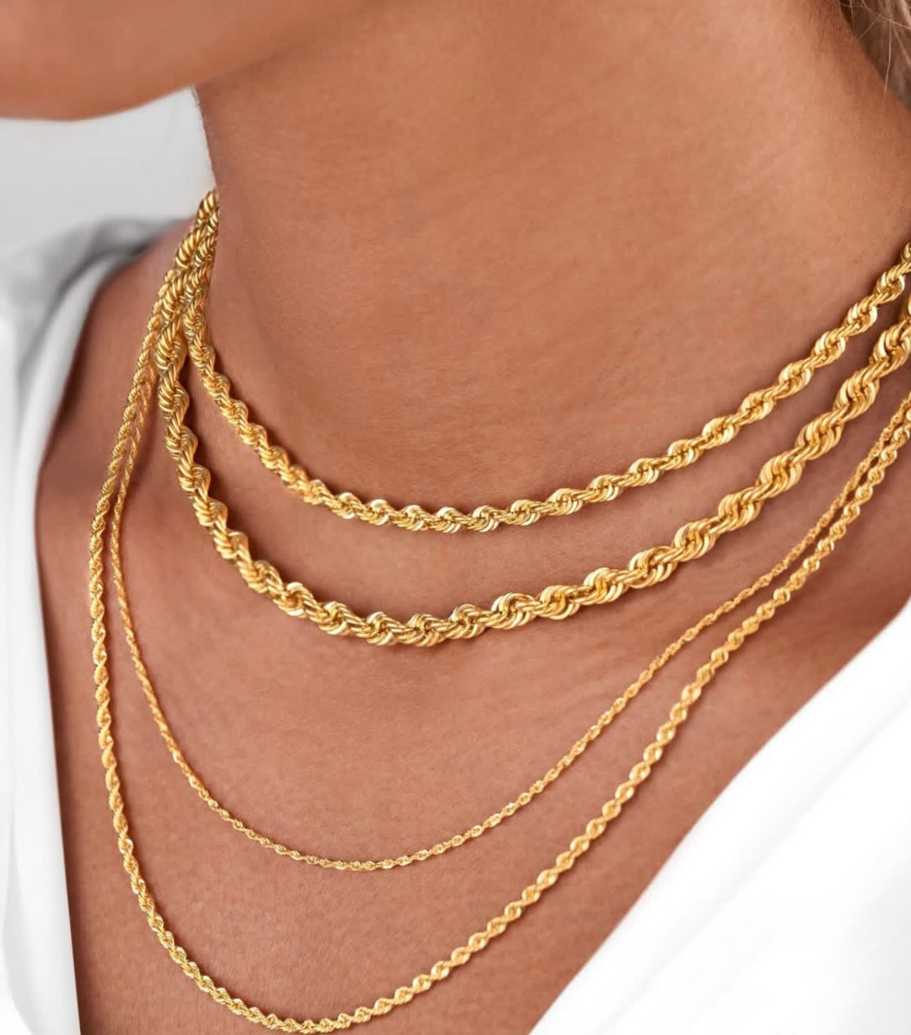 Layering-Look mit mehreren goldenen Kordelketten aus 18k – Tanab-e Tala in verschiedenen Stärken und Längen am Hals getragen