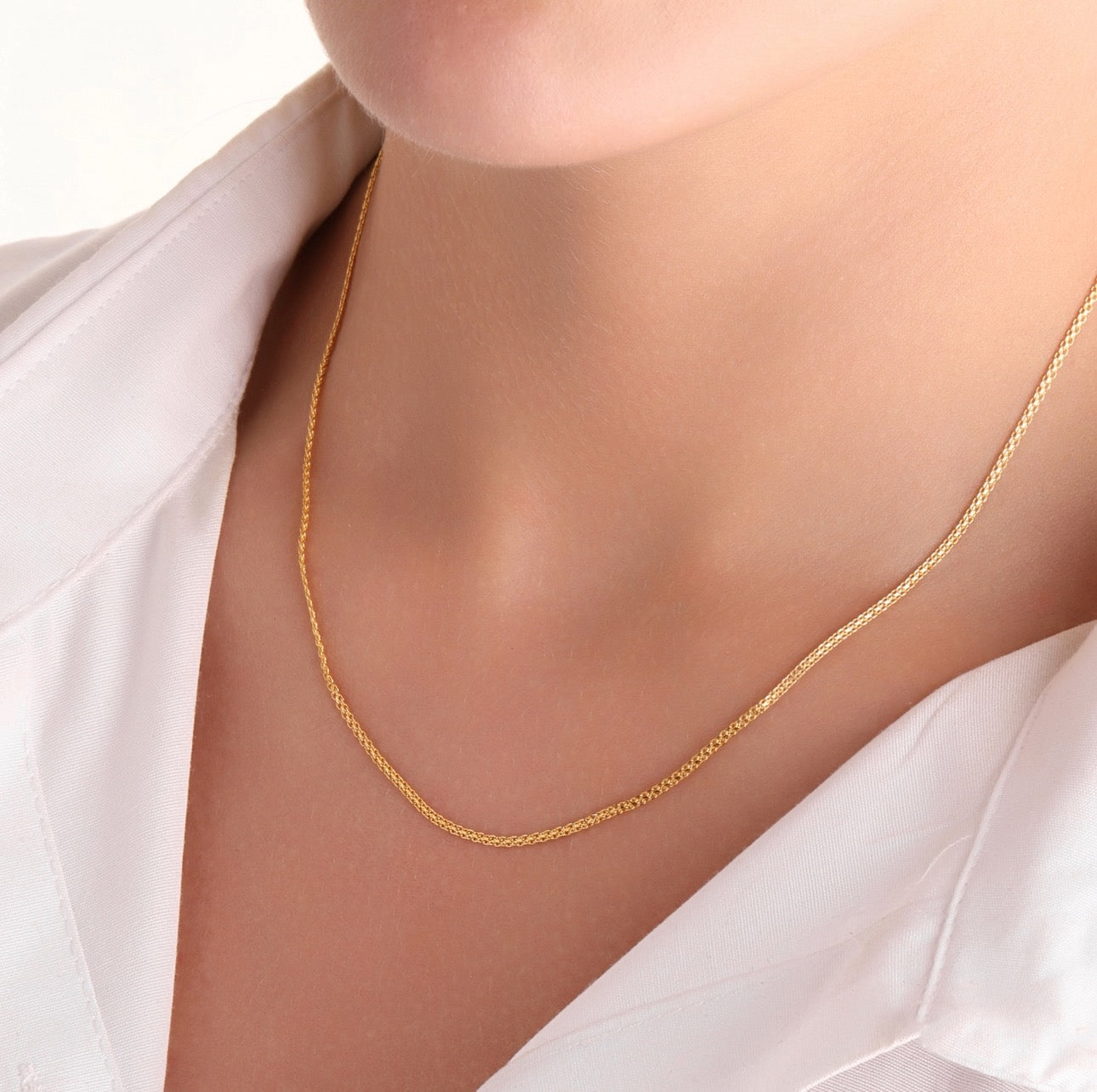 Feine 18k Bismarck-Goldkette – elegant getragen am Hals, kombiniert mit weissem Kragenhemd, dezenter Look mit Stil und Substanz