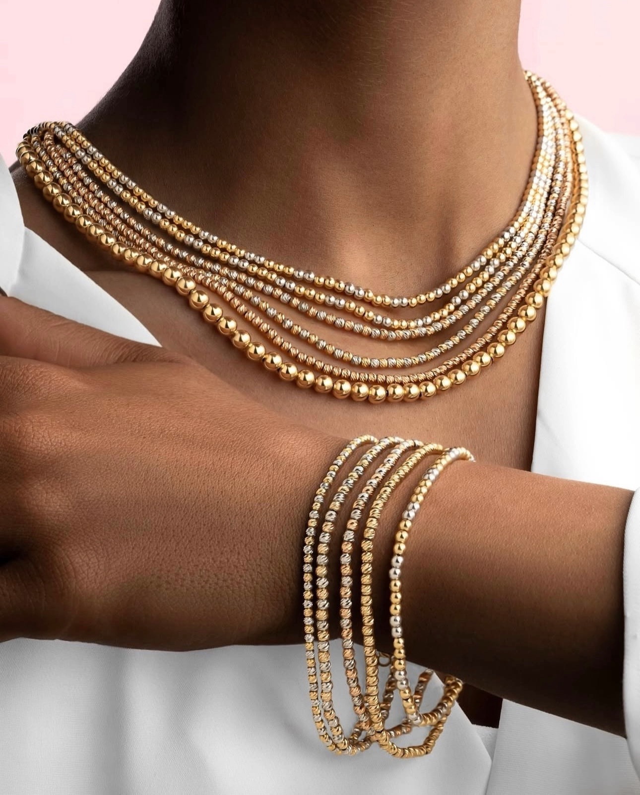 Sad-o Panjah Gooy-e Tala als Kette & Armband-Set – 18k Goldperlen in Gelb und Weiß, stilvoll getragen auf dunkler Haut zur weißen Kleidung