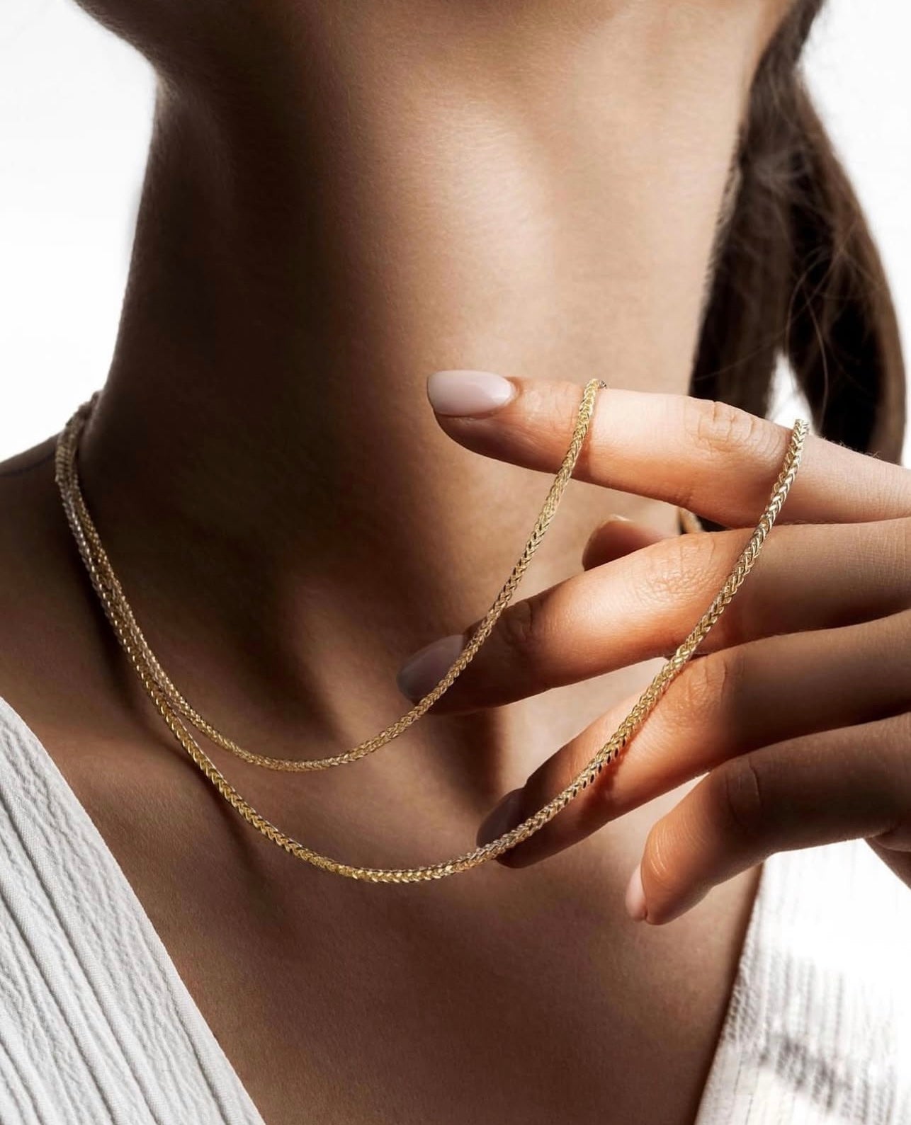 Zanjir-e Miro-ye Zarif-e Dorang – filigrane zweifarbige Mirokette, kunstvoll zwischen den Fingern eines weiblichen Models mit heller Haut