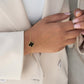 Zweifarbiges Kleeblatt-Armband Shabdar-e Do Rang aus 18k Gelbgold mit schwarzem Inlay – getragen am Handgelenk zu hellem Blazer