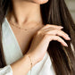 feine Kette mit dezenten Goldkügelchen, getragen am Handgelenk, elegantes und minimalistisches Schmuckdesign im Set mit passender Halskette.