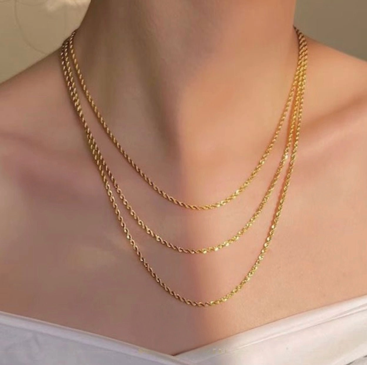 Goldkette Tanab-e Tala aus 18k Gold in verschiedenen Längen im Layering-Look getragen