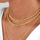Layering-Look mit mehreren goldenen Kordelketten aus 18k – Tanab-e Tala in verschiedenen Stärken und Längen am Hals getragen
