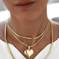 Dreifach getragene Zanjir-e Mari mit goldglänzendem Herzanhänger – elegante Layer-Kombination aus 18k Gelbgold