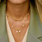 Zanjir Tala-e Morvarid kombiniert mit Perlenketten im Layering-Look – Goldperlen-Highlight auf V-Ausschnitt & Blazer