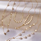 Elegante Halsketten aus 18k Gelbgold mit weißen Perlen, in verschiedenen Längen und Anordnungen, die Perlen wie tanzend auf den feinen Goldketten verteilt, sanft im Licht schimmernd.