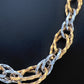 Grossaufnahme einer edlen Halskette aus 18k Gold in Gelb und Weiß mit gehämmerter Oberfläche. Persische Goldschmiedekunst in moderner Interpretation.